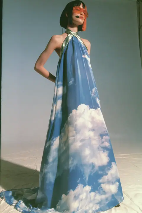 Y2K high fashion editorial, a 2001 couture magazine story: full-length shot, head to toe with the feet in frame, of a young Caucasian American woman with pale skin and a glossy black blunt bob with heavy straight…